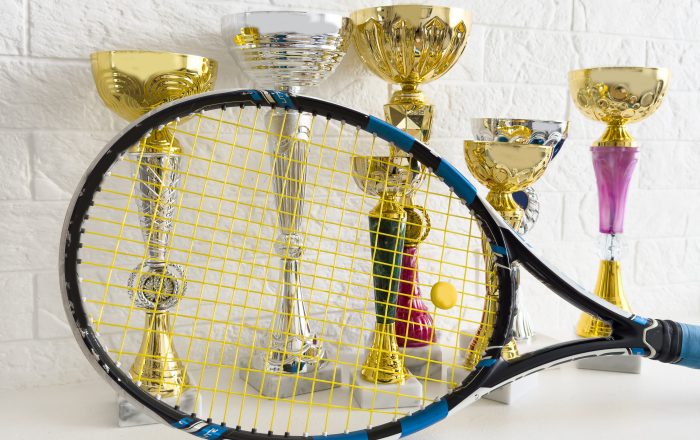 Sports, award and trophy at court for success, winner or achievement. Prize, victory and sport reward on a ground at an empty stadium for sport, champion and competition. tennis trophy. High quality photo